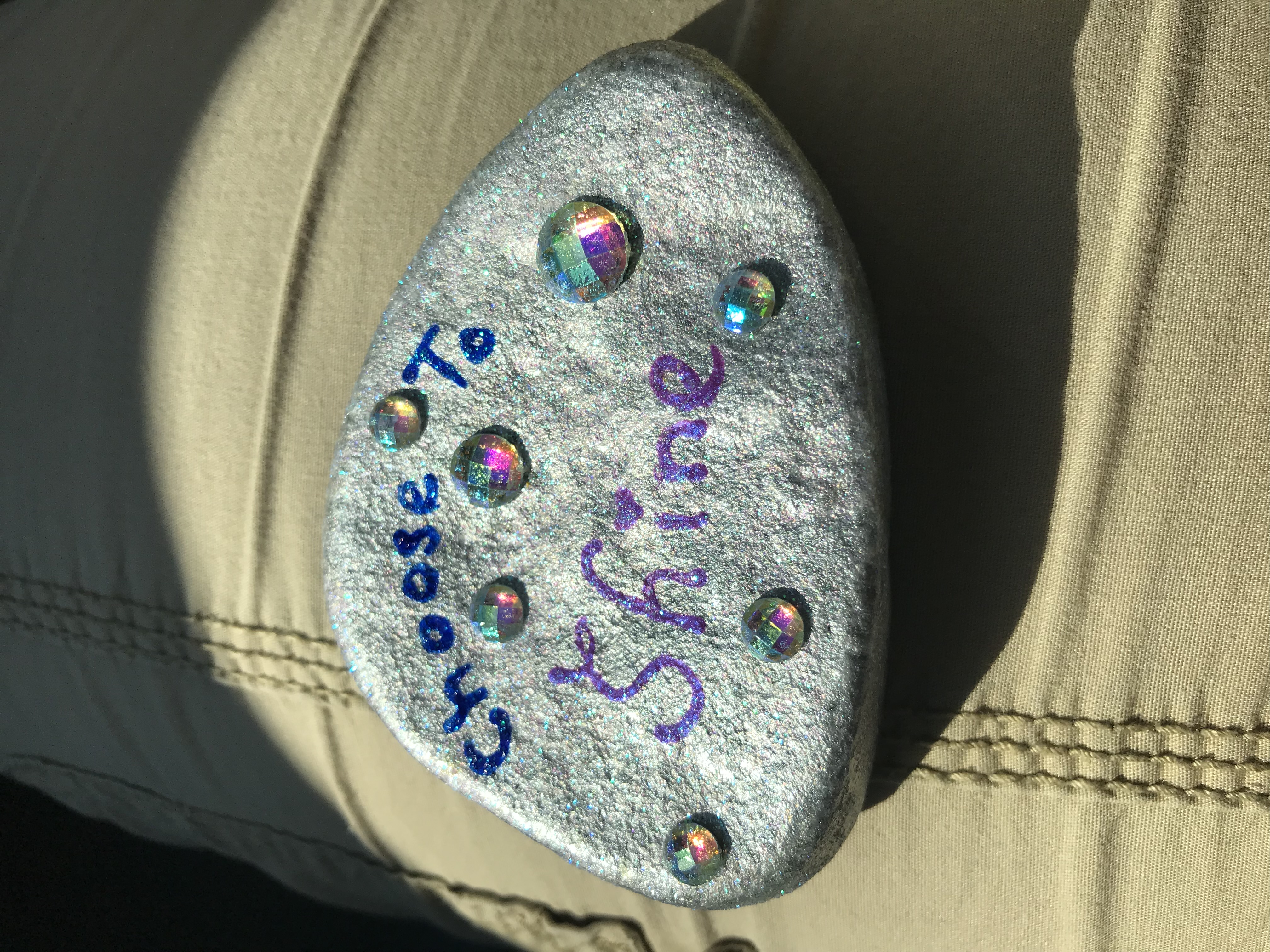 The original silver Choose to Shine painted stone before it began its journey.
